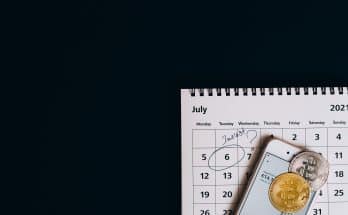 des pièces de bitcoin sur un smartphone et un calendrier